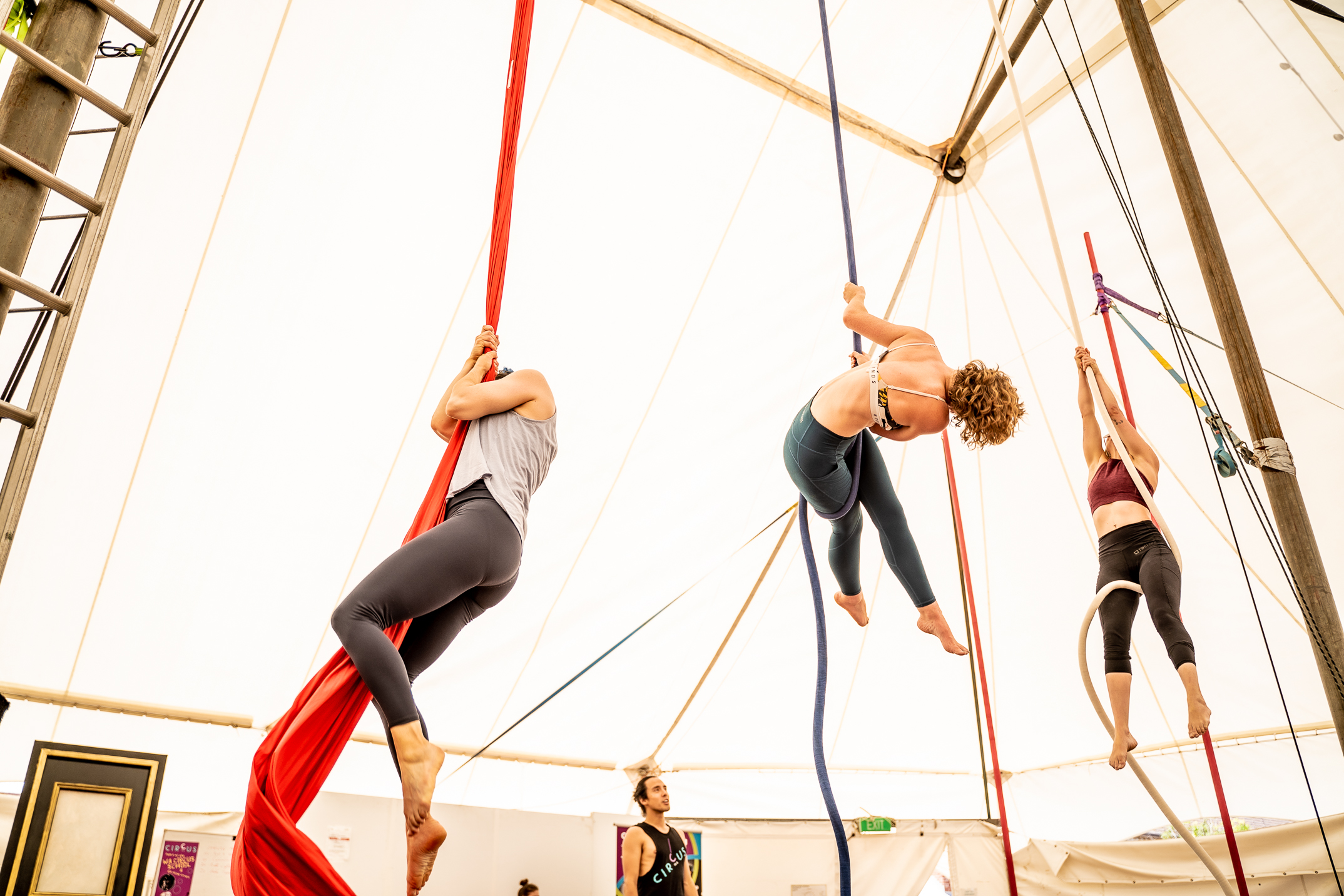 3 people do trick on aerial rope and silks